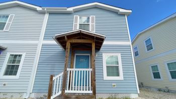 A blue house with a white door and windows.